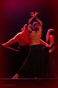une danseuse bras en l'air main croisées en pose