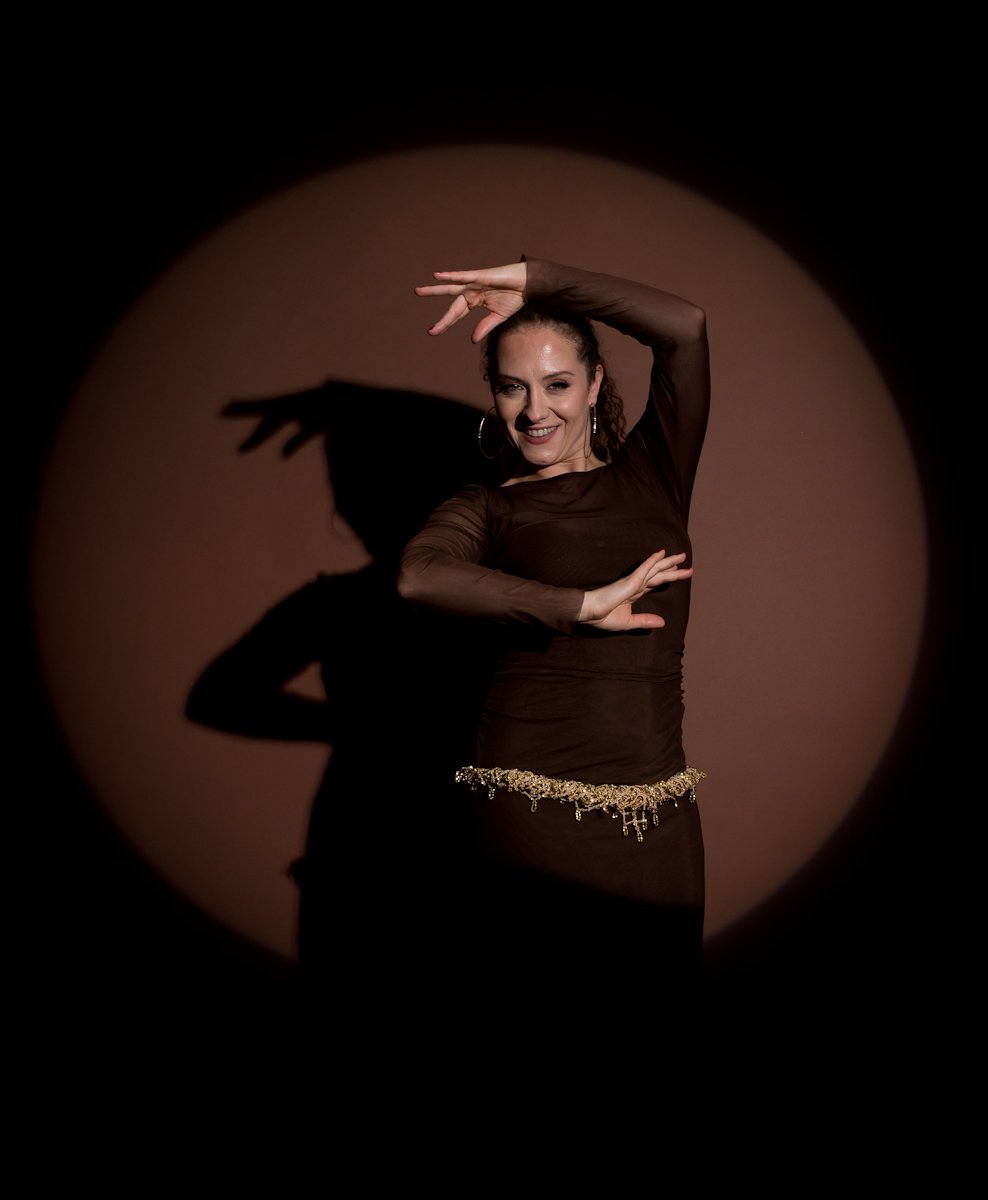 Danseuse orientale dans un mouvement contemporain entouré de marron