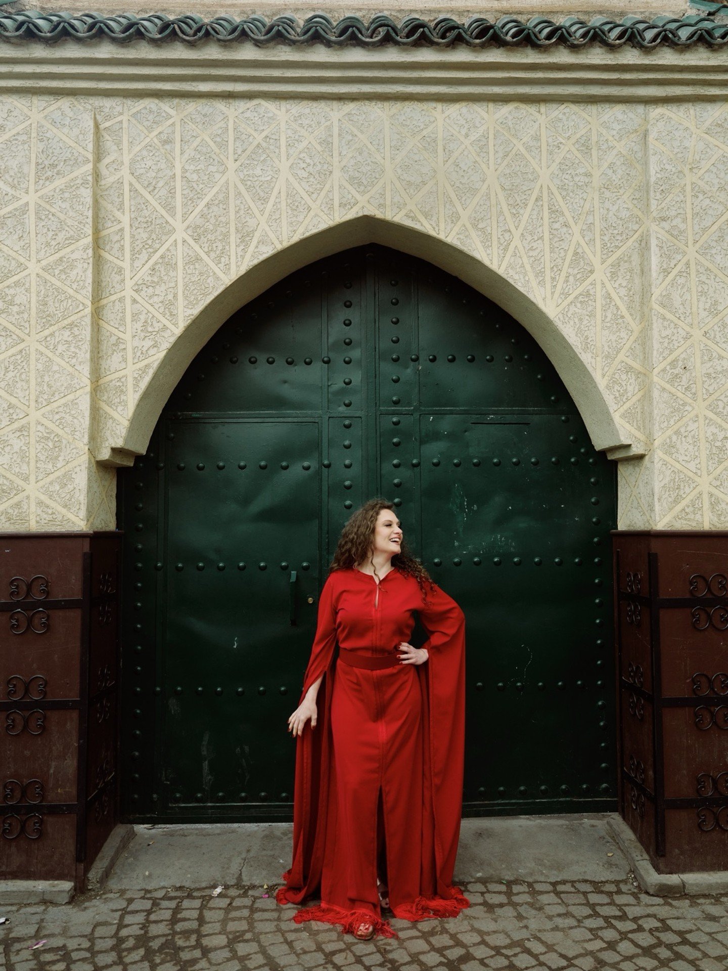 danseuse qui pose devant une grande porte à Marrakech